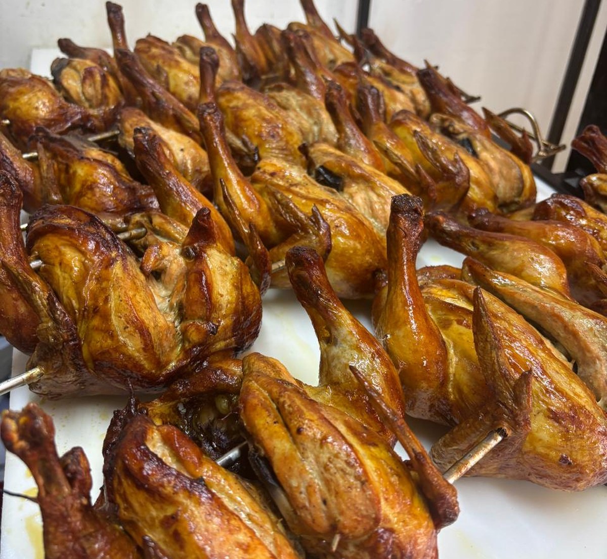 Pollos rostizados Pok Pok dorados en rosticera